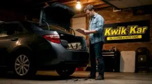 Car owner checking vehicle with clipboard in driveway