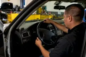 Technician diagnosing steering wheel vibration