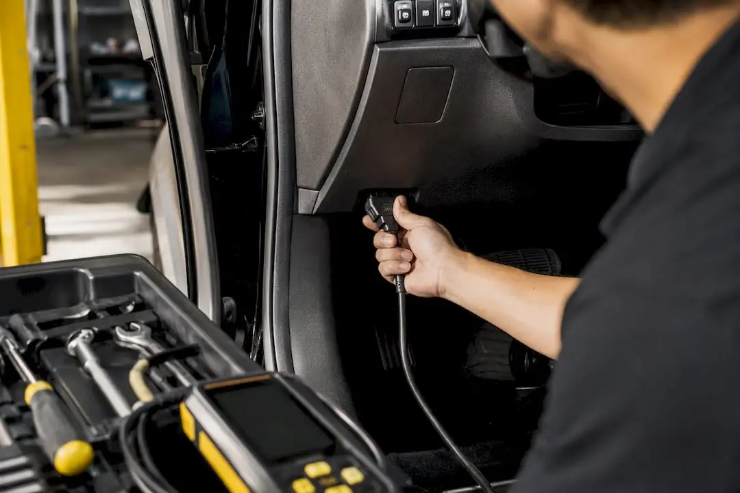 Technician plugging OBDII scan tool into car port