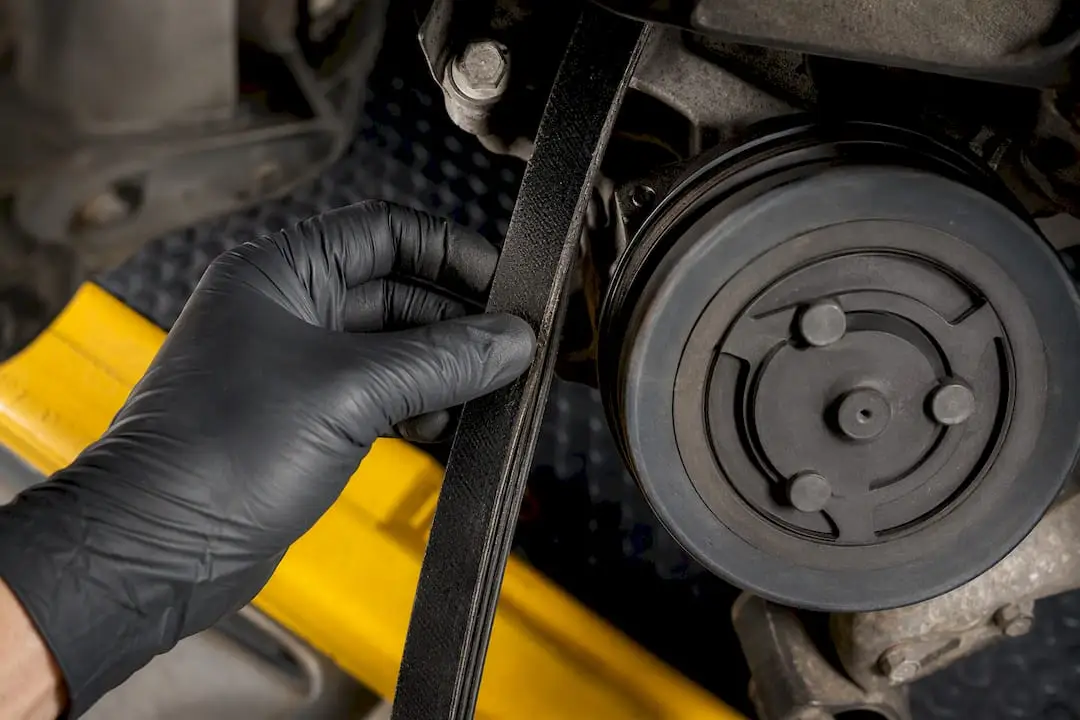 Technician inspecting serpentine belt and pulley
