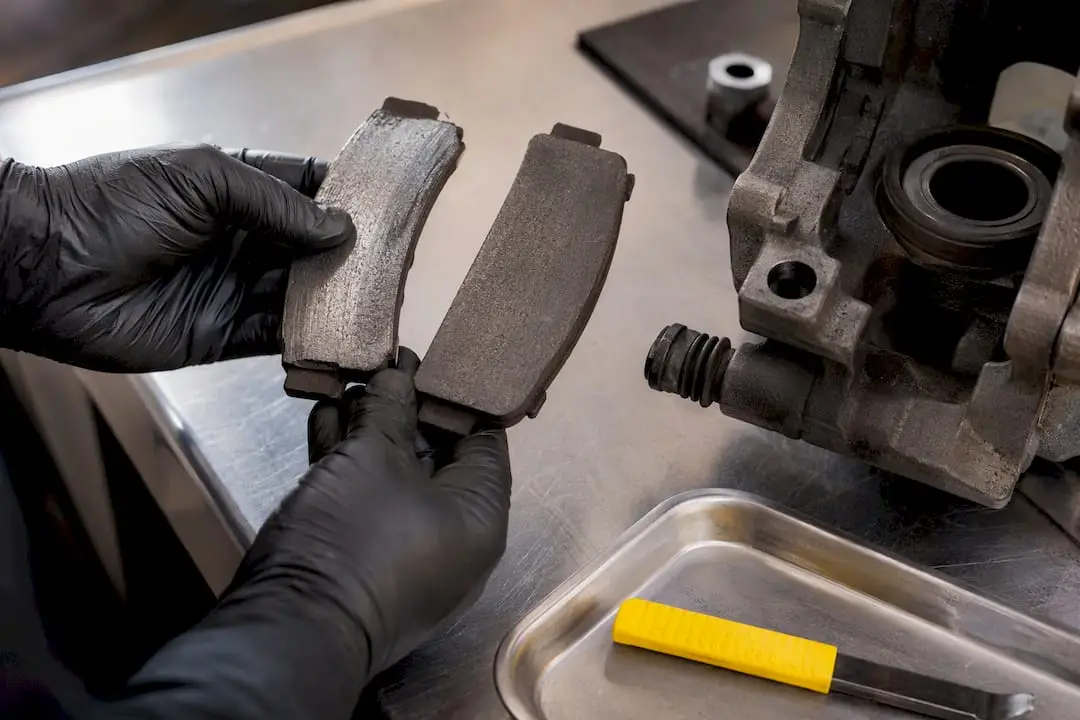 Technician examining uneven brake pad wear