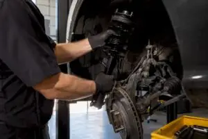 Technician installing a front strut assembly