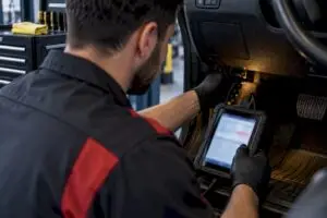 Technician connecting engine diagnostic scanner