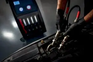 Technician connecting transmission fluid service hoses