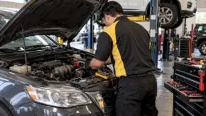 Technician testing vehicle alternator charging output